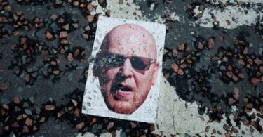 A mask of co-owner Joel Glazer is on the ground during protests in August 2022