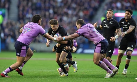 New Zealand full-back Beauden Barrett tries to break Scotland’s line
