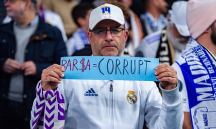 A Real Madrid supporter holds up a sign about Barcelona during the Champions League second leg against Liverpool