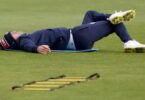 Jimmy Anderson grimaces and stretches