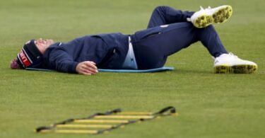 Jimmy Anderson grimaces and stretches